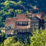 Vedere panoramică din cetatea Cetatea Cisnădioara, cu zidurile de apărare și peisajul munților în fundal.